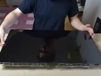 The man repairing broken. He installs a TV screen.